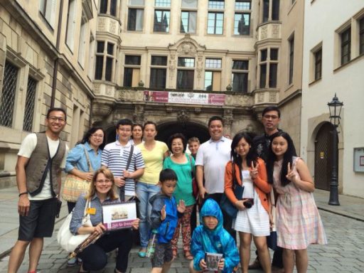 Gruppe von Personen vor einem historischen Gebäude in einer Stadt.